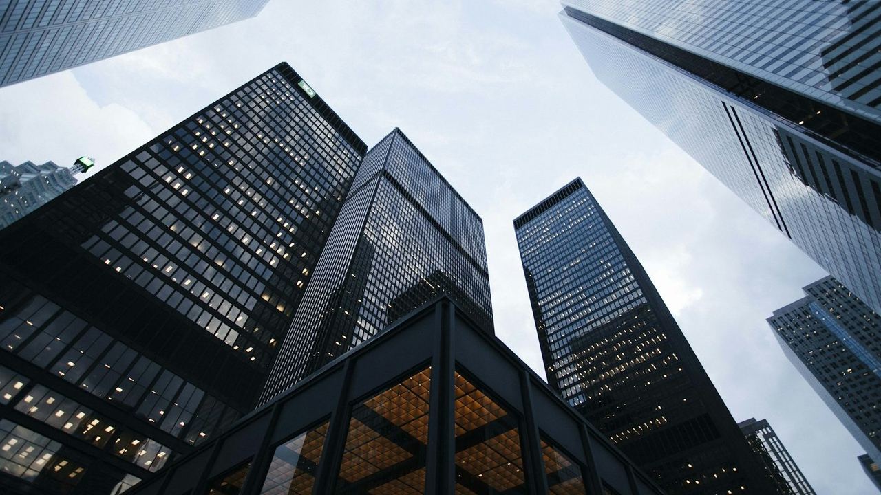 Glass office towers seen from below against the sky